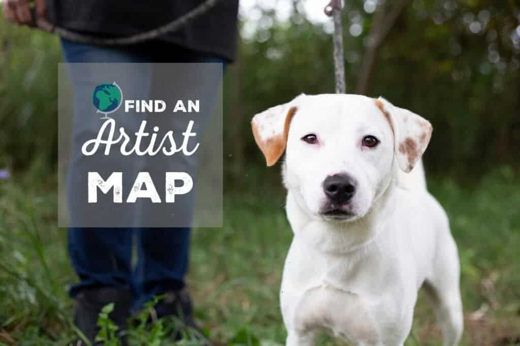 White dog looking directly into camera with the text Find An Artist Map written beside him with the graphic of a globe